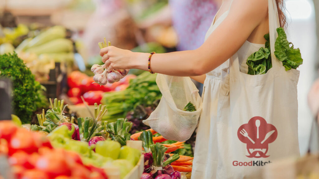 A woman shops at a grocery store while carrying a custom screen printed tote bag.